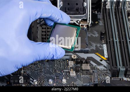 Plug in CPU microprocessor to motherboard socket. Technological background. Concept computers harware. Stock Photo