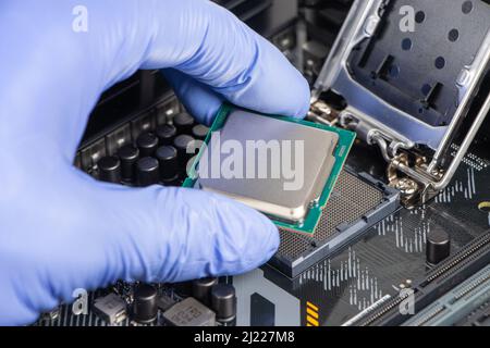 Plug in CPU microprocessor to motherboard socket. Technological background. Concept computers harware. Stock Photo