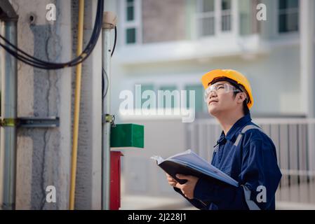An Engineer is reading a document and checking the communication line. Stock Photo