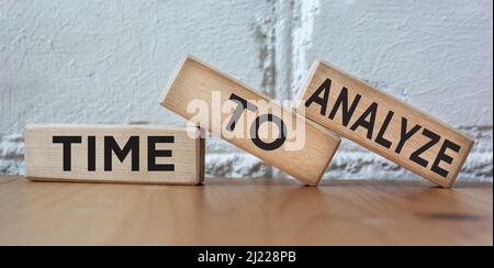 Time to Analyze, text concept written on wooden blocks lying on a light table Stock Photo