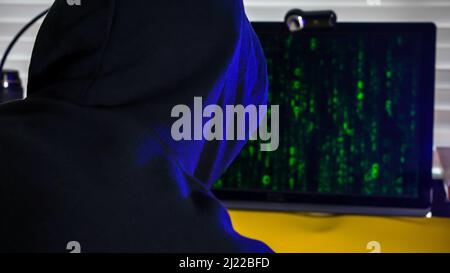 Person silhouette upfront computer screen with digital code on screen Stock Photo