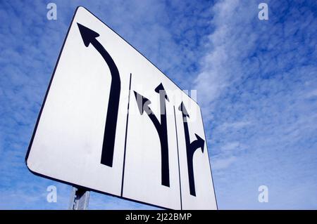 Multi directional turn signs for traffic drivers an indication on which way to chose, go left, right or straight ahead from each of the 3 lanes Stock Photo