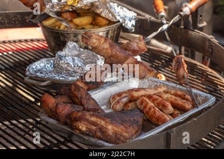 Barbecue fried sausages background, close-up. Sausage kebab on coals. Traditional cooking. Family picnic in the open air. Selective focus. Meat Blends Stock Photo