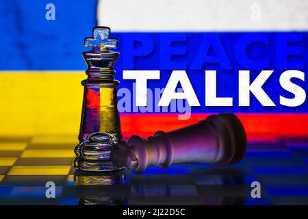 Fallen chess king as a metaphor for fall from power Peace Talks ukraine invasion ukrainian and russian flag background Stock Photo