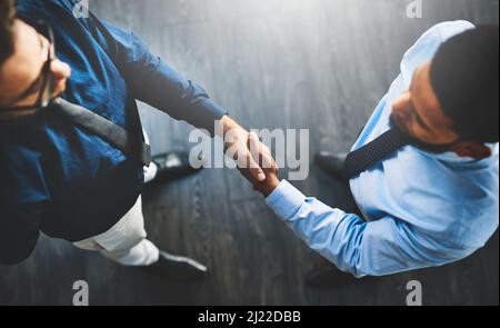 Its a done deal. Shot of two businessmen shaking hands in an office. Stock Photo