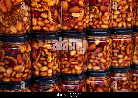 Nuts with honey in glass jars. Harvest of nuts. Delicacy and Healthy food. Homemade preservation in autumn Stock Photo