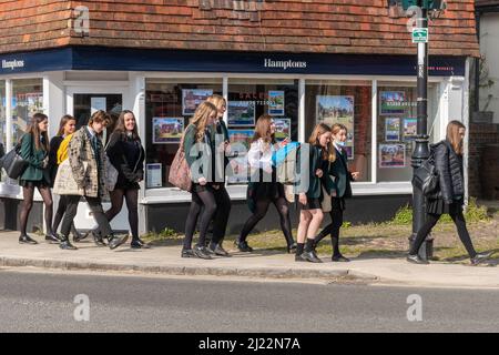 Secondary school children pupils students walking home after school through Liphook centre, Hampshire, England, UK Stock Photo