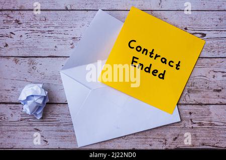 Contract ended text on yellow notepad with envelope background. Employment and termination concept Stock Photo