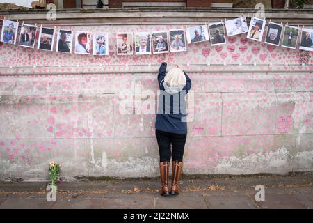 A family member pays their respects to those who lost their lives to Covid 19 as they mark the one-year anniversary of National Covid Memorial Wall, London. Picture date: Tuesday March 29, 2022. Stock Photo