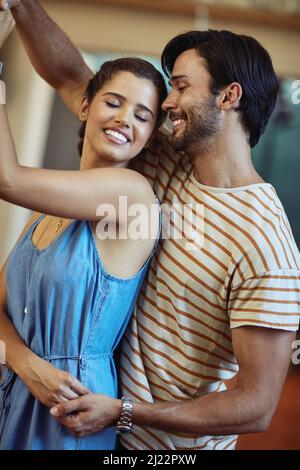 You are my hearts dancing partner. Shot of an affectionate young couple dancing in their kitchen at home. Stock Photo