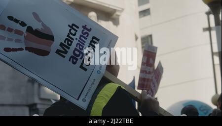 London, UK - 03 19 2022:  A man at Portland Place holding a sign, ‘March Against Racism’, for the yearly ‘March Against Racism’. Stock Photo