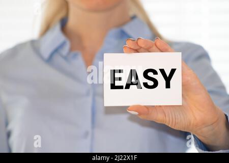 EASY message on the card shown by a man, vintage tone. Stock Photo