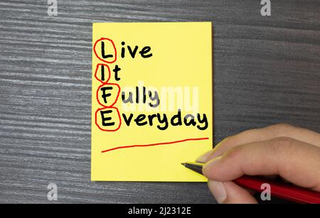 LIFE - Living In Freedom Every Day - handwriting on notebook with cup of coffee and pen, acronym business concept Stock Photo