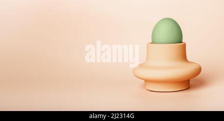 Banner with green dyed Easter egg in cup, server or holder on beige background. Religious holiday symbol. Breakfast food. Space for text. High quality photo Stock Photo