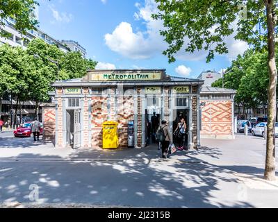 Paris, France - June 12, 2015: people at entrance to the metro station with typical architecture in art nouveau style.