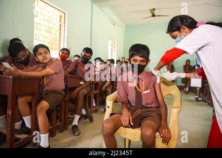 School students in the age group of 12 to 14 years waiting at a classroom to receive a dose of Corbevax Covid-19 preventive vaccine at a school. Agartala, Tripura, India. Stock Photo