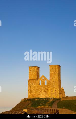 The twin towers of the ruined church of St Mary at Reculver, lit by the setting sun. Kent, England. Stock Photo