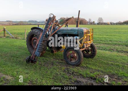 An old antique hedge trimmer mounted on a vintage tractor Stock Photo