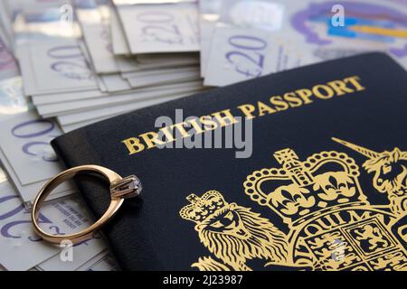 Engagement ring with diamond on top of a new dark blue British passport. Concept for UK Fiance visa or Spouse Visa. Stafford, United Kingdom, March 29 Stock Photo
