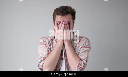 Desperate upset senior man holding hands on face. Studio shot Stock Photo