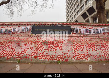 London, England, UK. 29th Mar, 2022. Photos of people who lost their lives to coronavirus have been hung on the National Covid Memorial Wall to mark one year since the memorial was created. Over 150,000 red hearts have been painted on the wall outside St Thomas' Hospital to date, one for each life lost to Covid-19. (Credit Image: © Vuk Valcic/ZUMA Press Wire) Stock Photo