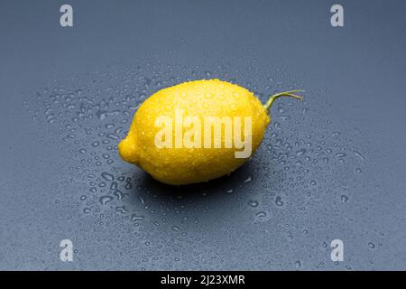 yellow lemon on gray background, composition of lemons and green leaves. Stock Photo