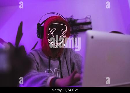 Hacker in action using his or her laptop. Anonymous person and identity theft. High quality photo Stock Photo