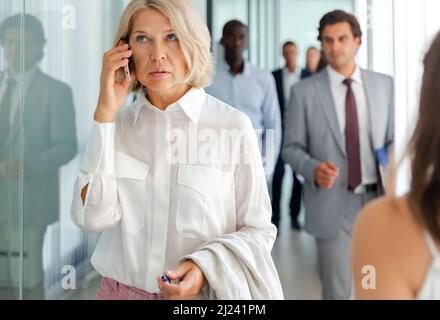 Mature business woman speaking phone Stock Photo