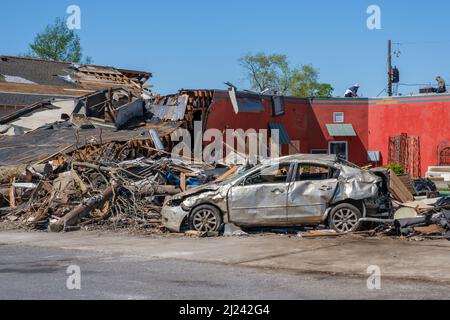 ARABI, LA, USA - MARCH 26, 2022: Pile of debris and severely damaged car near undamaged business on Friscoville Avenue after tornado touched down Stock Photo