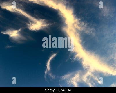 Abstract Swirl of Sunlit Cirrus Clouds Against a Deep Blue Sky Stock Photo