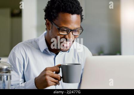 Im always productive at home. Shot of a handsome young businessman working on his laptop at home. Stock Photo