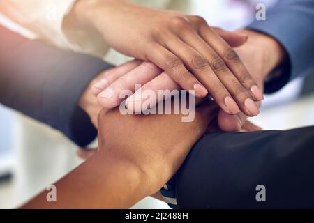 Many hands and one vision make a successful team. Closeup shot of a group of colleagues joining their hands together in unity. Stock Photo