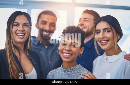 Were making waves in the business world. Portrait of a cheerful group of young businesspeople smiling and posing together at work. Stock Photo