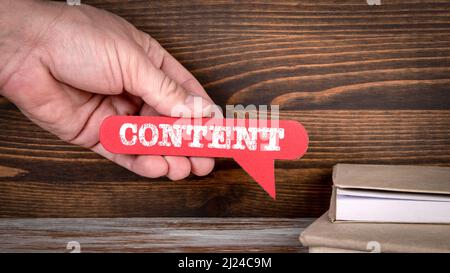 Content. Red speech bubble in a man's hand. Stock Photo