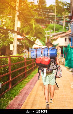 Seeing the city on foot. Rearview shot of a young backpacker exploring a foreign city on his own. Stock Photo