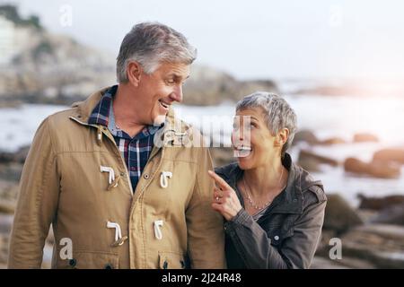 Taking a stroll at the beach with my love. Shot of a beautiful elderly couple taking a walk at the beach. Stock Photo