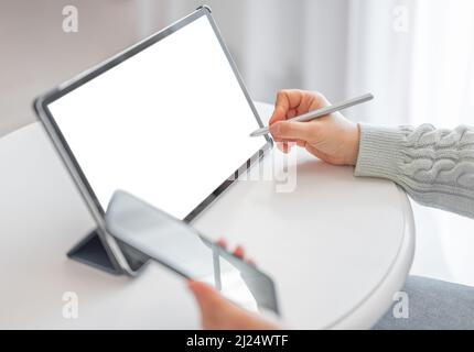 Businesswoman working on digital tablet with stylus. female entrepreneur checking few financial reports on mockup tablet computer with blank white scr Stock Photo