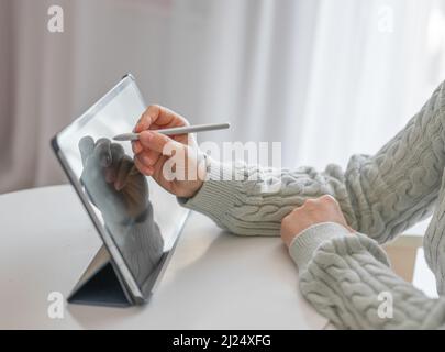 female artist using smart stylus for drawing picture on tablet touch screen device, working home, talented graphic designer drawing on tablet using pe Stock Photo