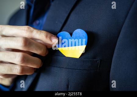 Ukraine flag color heart in suit pocket Stock Photo