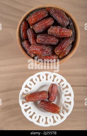 Date fruit in two bowl on wooden background, top view Stock Photo