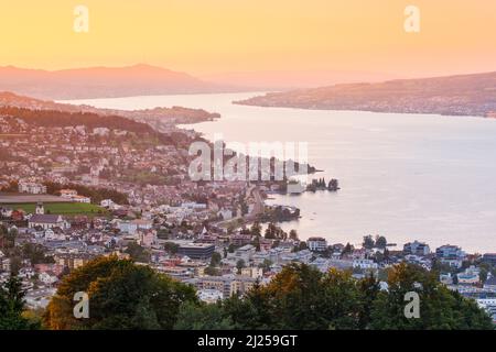 View at dusk from Feusisberg over Lake Zurich to Zurich, with the illuminated villages Wollerau, Richterswil, Wawdenswil and Meilen and the Uetliberg in the background, Canton Zurich, Switzerland Stock Photo