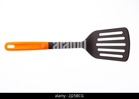 A black plastic spatula with orange handle Stock Photo