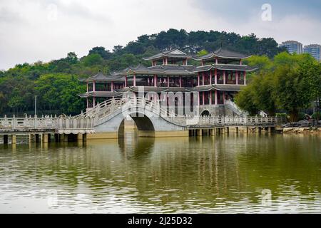 Chinese style pedestrian stone arch bridge over lake in park Stock Photo