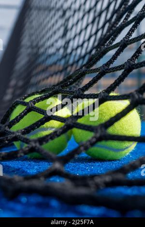 selective approach, two paddle tennis balls behind the net of a blue paddle tennis court Stock Photo