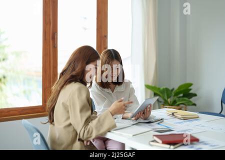 Young asian fund managers team consultation and discuss about analysis Investment stock market by digital tablet Stock Photo