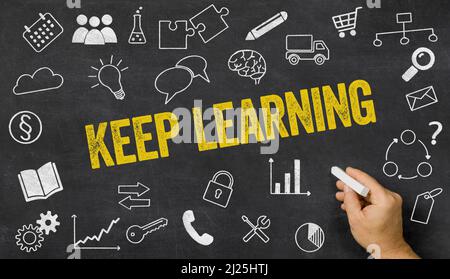 Keep learning written on a blackboard with icons Stock Photo
