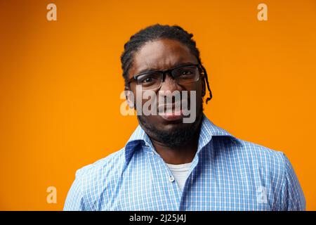 Young black man feeling shocked, amazed over yellow background Stock Photo