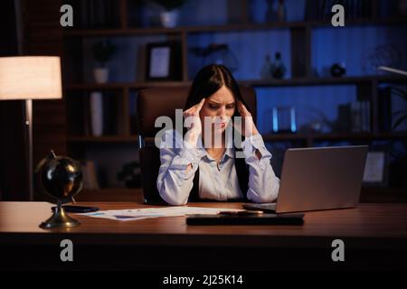 Tired businesswoman working overtime in office. Stressed worker have financial problems and searching ideas to overcome financial crisis. Entrepreneur Stock Photo