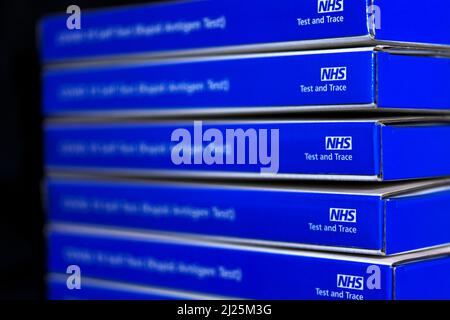 Blue NHS Covid-19 lateral flow test kit boxes / rapid lateral flow antigen coronavrus test kits against a black background Stock Photo