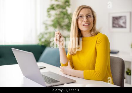 Thoughtful woman using laptop Stock Photo